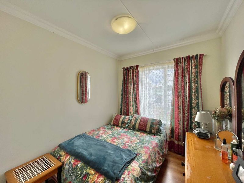 A standard bedroom featuring neutral walls, coving, and a window with natural light.