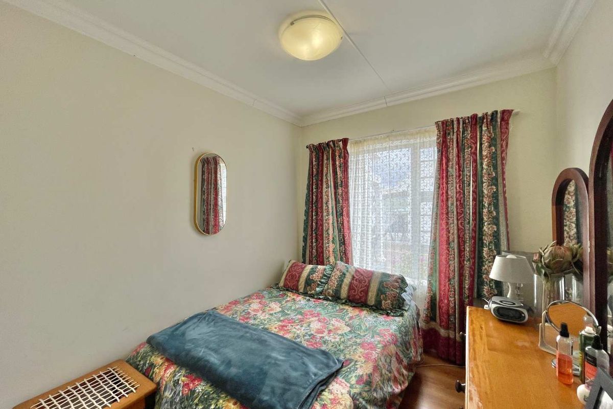 A standard bedroom featuring neutral walls, coving, and a window with natural light.