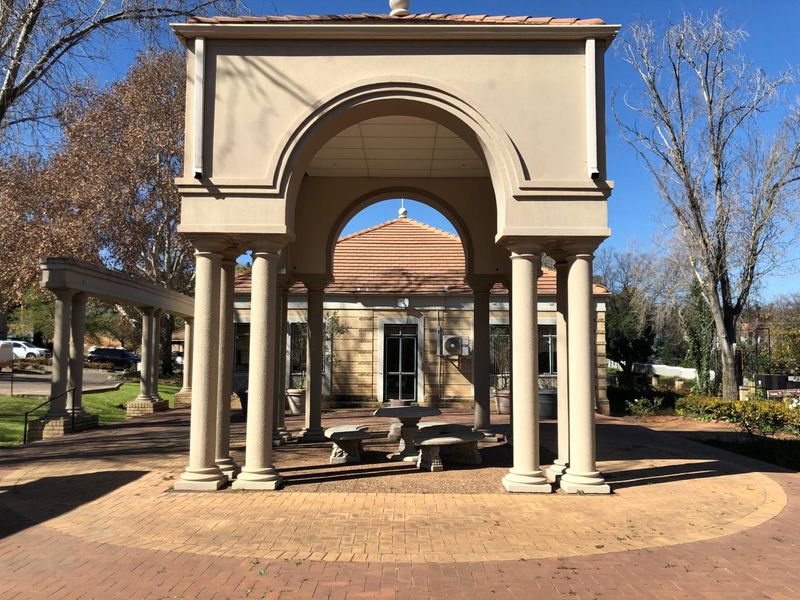 A well-maintained outdoor pavilion featuring stone columns and a paved courtyard area, providing a structured and pleasant exterior space.