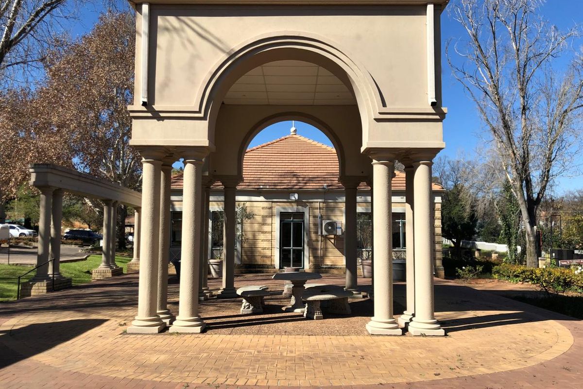 A well-maintained outdoor pavilion featuring stone columns and a paved courtyard area, providing a structured and pleasant exterior space.