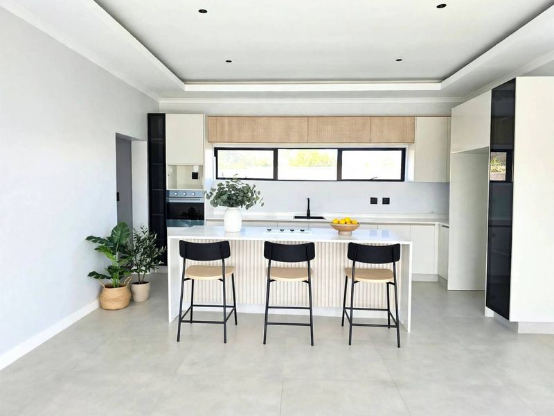 Modern kitchen featuring a central island, sleek built-in cabinetry, integrated appliances, and recessed ceiling lighting with a clean, contemporary aesthetic.