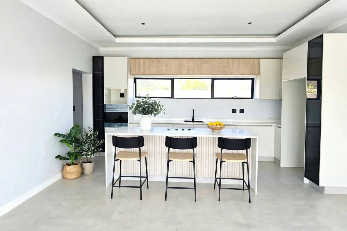 Modern kitchen featuring a central island, sleek built-in cabinetry, integrated appliances, and recessed ceiling lighting with a clean, contemporary aesthetic.
