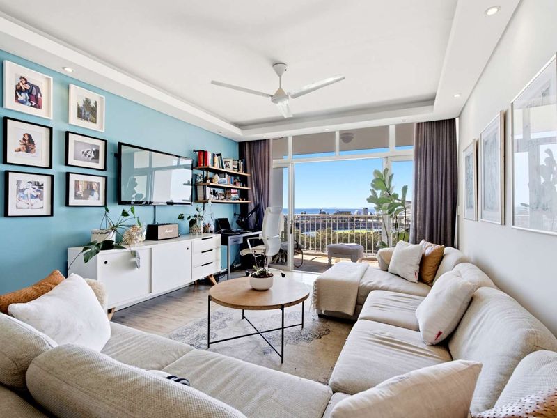 Bright and modern living room featuring laminate flooring, recessed lighting, a ceiling fan, and direct access to a balcony with scenic views.