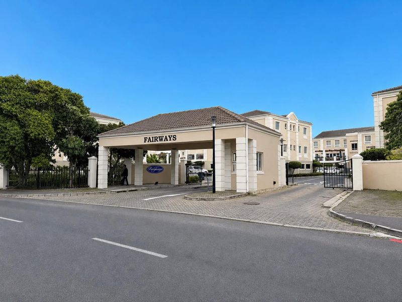 The main entrance and security gatehouse of the Fairways office complex, featuring paved access and well-maintained perimeter structures.