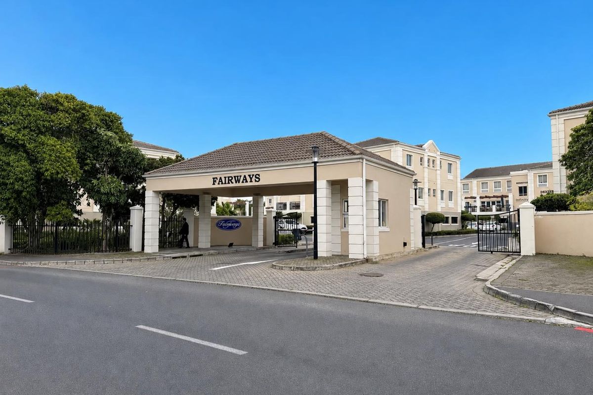 The main entrance and security gatehouse of the Fairways office complex, featuring paved access and well-maintained perimeter structures.