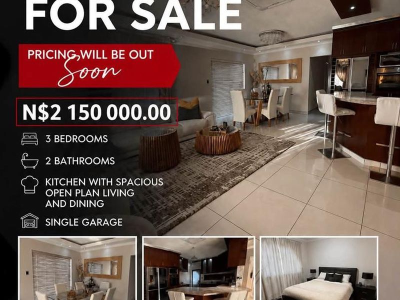 A spacious open-plan living, dining, and kitchen area featuring modern cabinetry, a central kitchen island, and tiled flooring throughout.