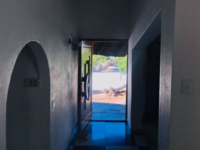 An entry hallway featuring checkered tile flooring and a distinctive arched wall niche, leading directly to the exterior entrance.