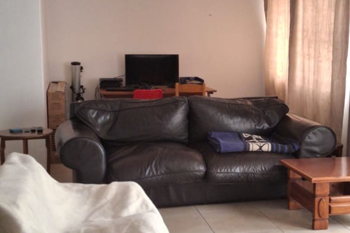 A living room featuring neutral tiled flooring and standard ceiling lighting, offering a functional space ready for modern updates and interior design improvements.