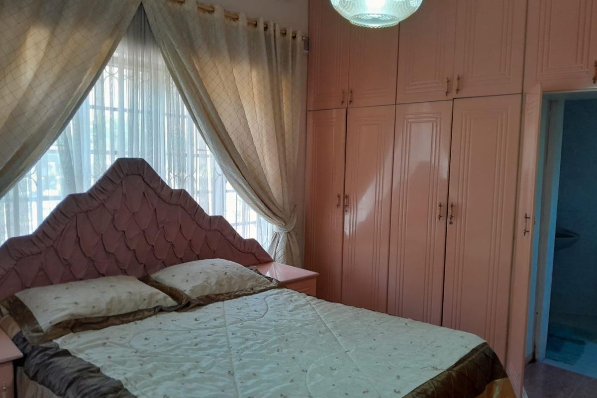A bedroom featuring floor-to-ceiling built-in wardrobes and a central light fixture, offering functional storage space.
