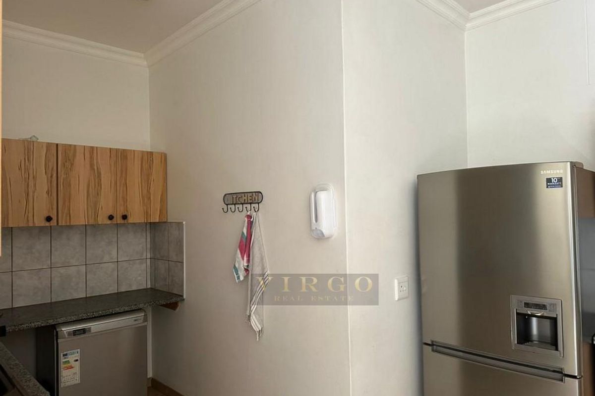 A functional kitchen area featuring laminate cabinetry, granite countertops, and tiled splashbacks, providing a practical workspace for daily culinary activities.