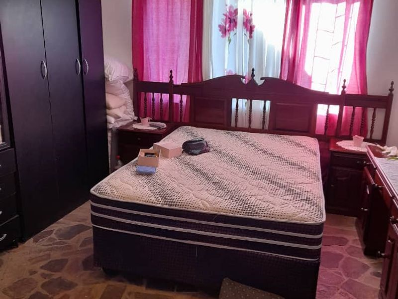 A bedroom featuring stone flooring and a built-in wardrobe, offering a rustic foundation for potential interior updates.