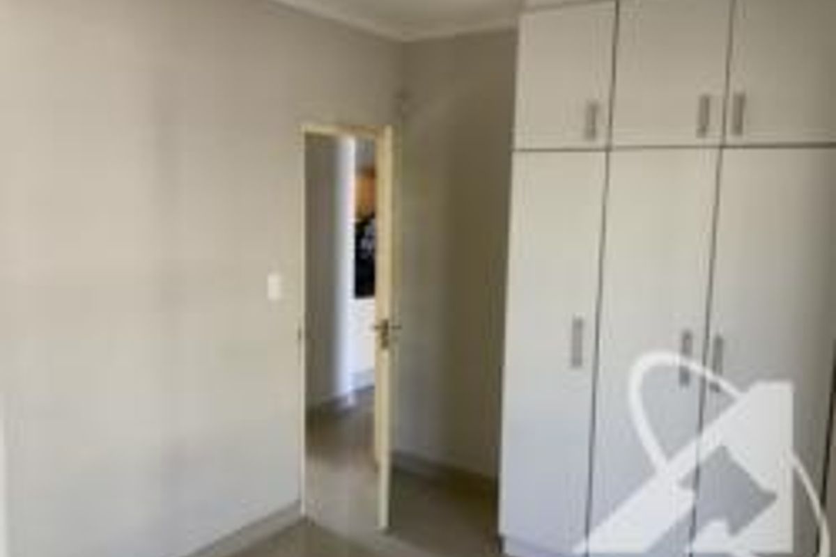 A bedroom featuring built-in cupboards and neutral wall finishes, providing a clean and functional space.