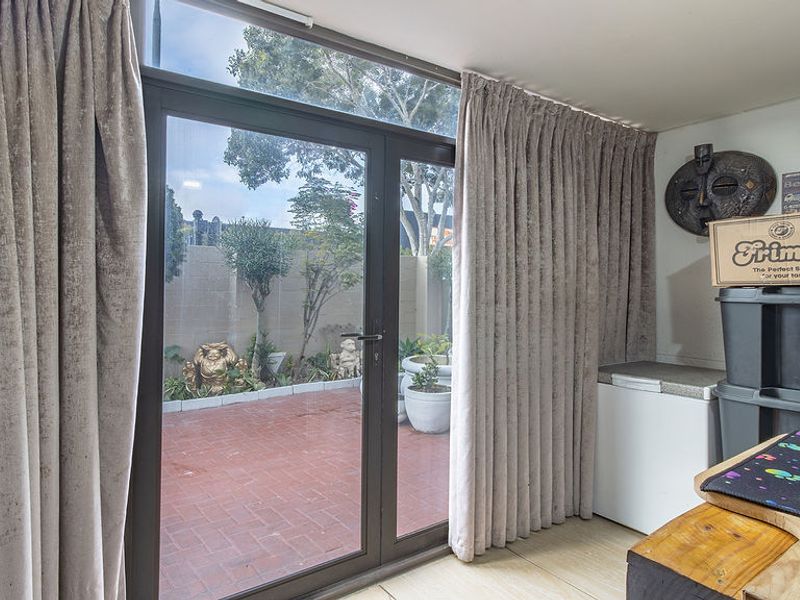 Living area featuring large aluminium sliding doors providing direct access to a paved outdoor patio space.