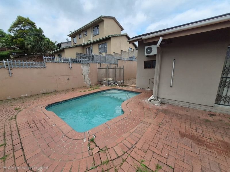 Outdoor pool area featuring brick paving, a boundary wall, and an exterior air conditioning unit, showing signs of wear and maintenance requirements.