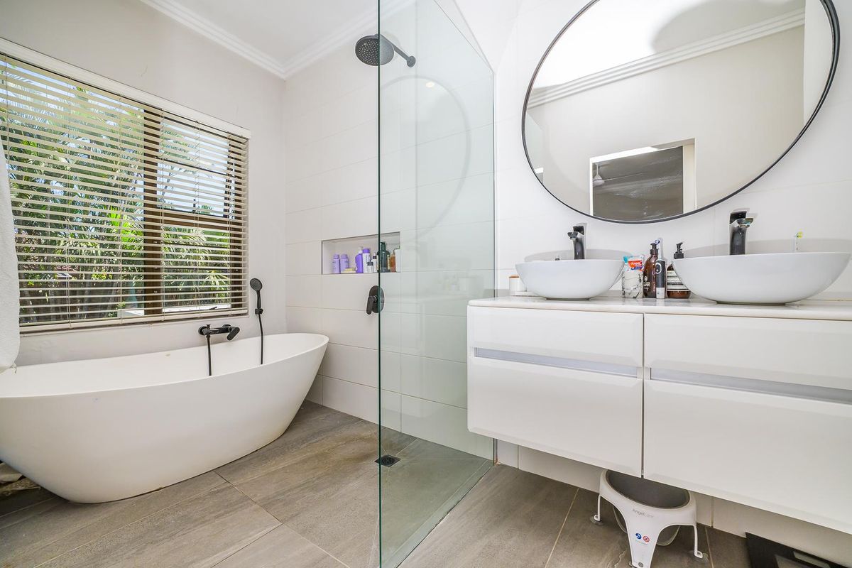 Modern bathroom featuring a freestanding bathtub, a glass-enclosed walk-in shower, and a double vanity with vessel sinks.