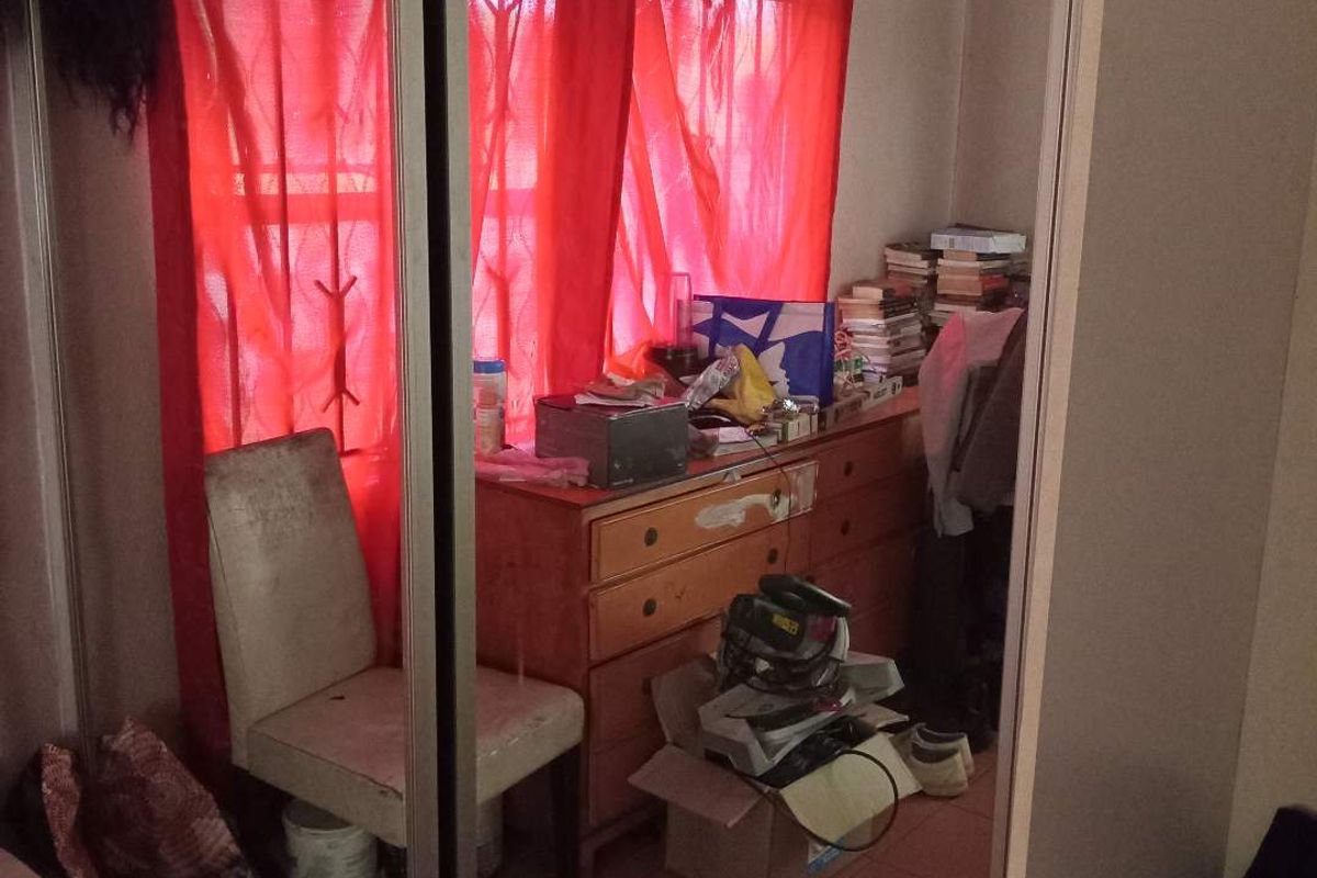 A bedroom featuring built-in mirrored sliding wardrobes and tiled flooring, offering a functional space ready for updates.