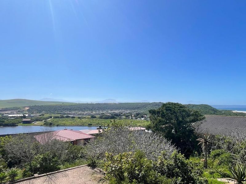 A scenic elevated view overlooking the estuary, surrounding greenery, and distant coastline, showcasing the natural landscape and peaceful setting of the property.