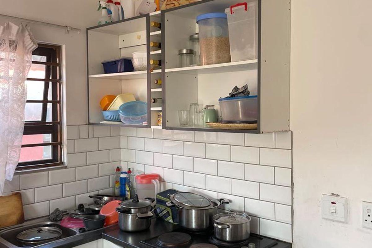 Compact kitchen featuring a subway tile backsplash, built-in oven, electric hob, and open shelving cabinetry.
