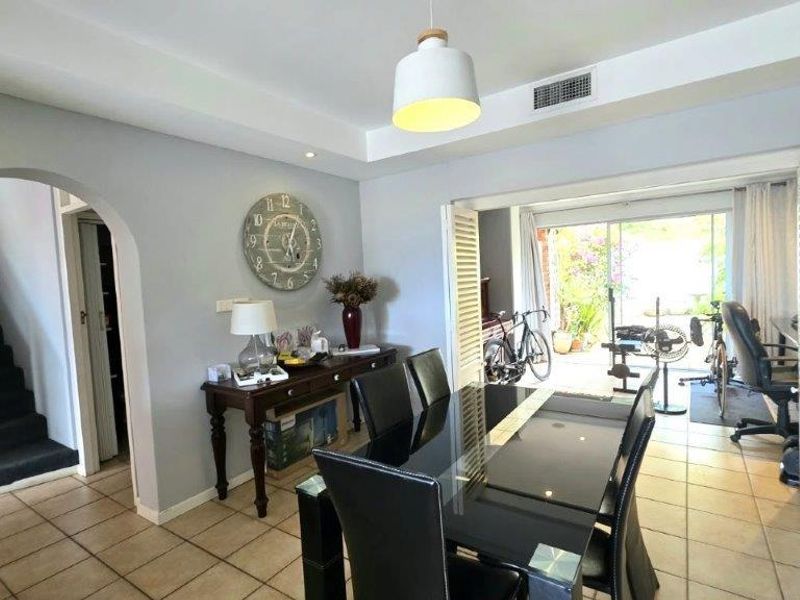 Dining room featuring tiled flooring, recessed lighting, and an arched entryway, with bi-fold doors opening to an outdoor patio area.