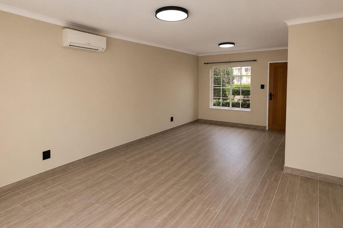 A bright, empty living room featuring modern tiled flooring, a split-system air conditioner, and neutral wall finishes, ready for personalization.