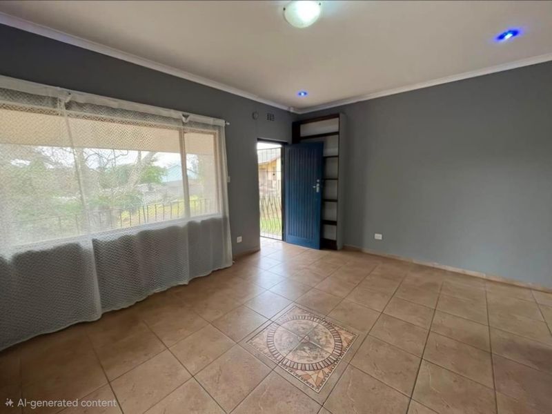 An empty living area featuring tiled flooring with a decorative inlay, recessed lighting, and a built-in shelving unit, leading to an exterior security gate.