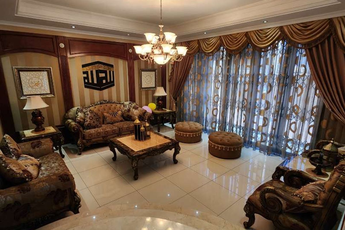 Spacious living room featuring elegant tiled flooring, decorative wall paneling, and a sophisticated recessed ceiling with integrated lighting.