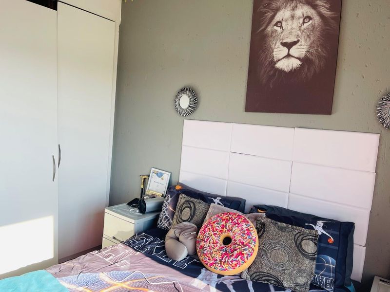 A bedroom featuring a built-in wardrobe and a wall-mounted headboard panel.