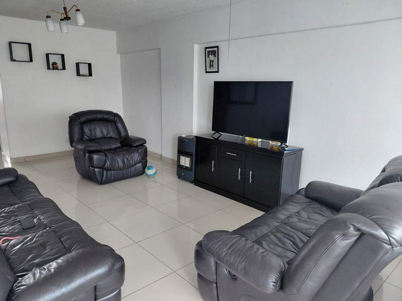 A spacious living room featuring neutral tiled flooring and a clean, minimalist layout, providing a versatile foundation for modern interior design updates.