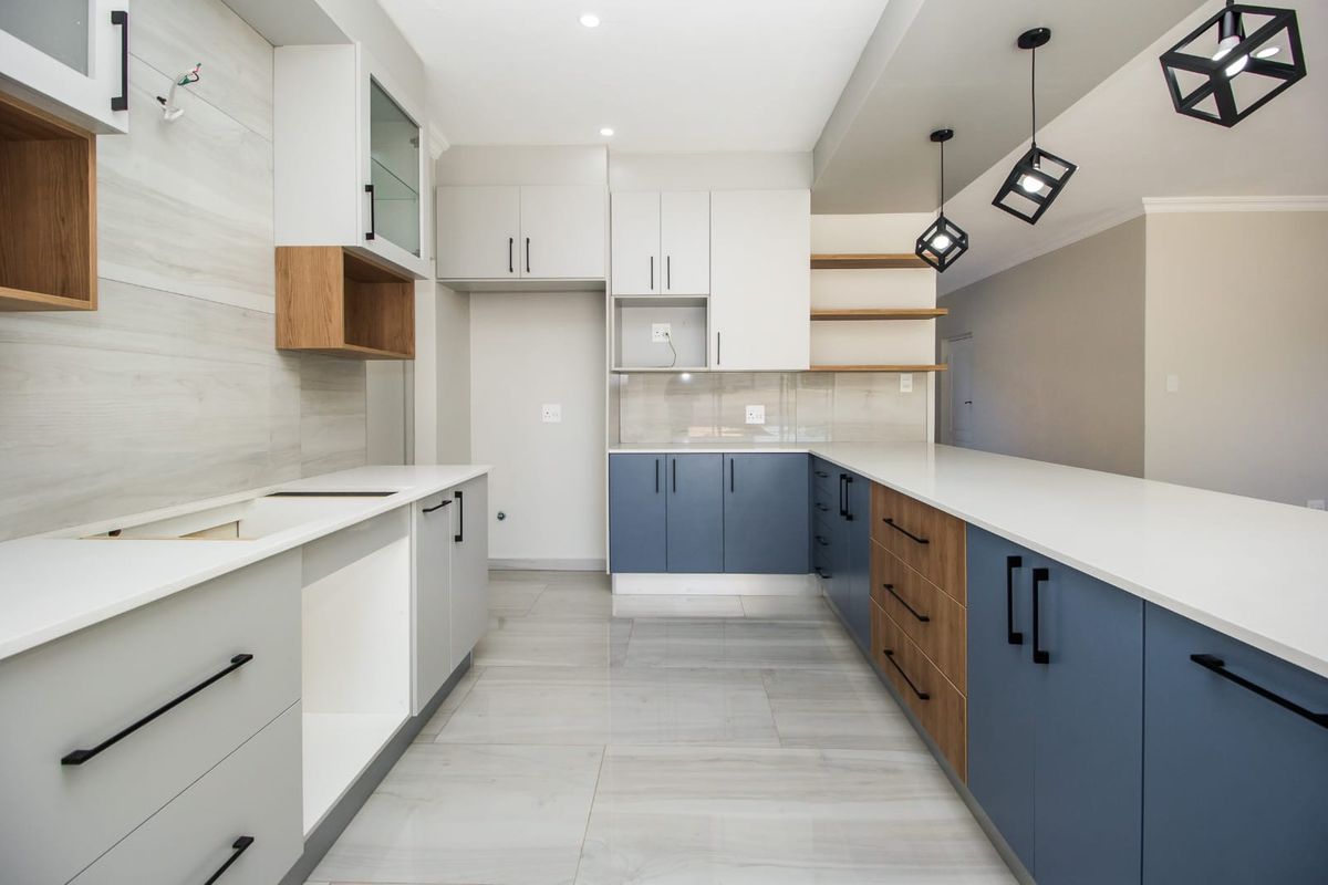Modern, newly renovated kitchen featuring two-tone cabinetry, quartz countertops, open shelving, and contemporary pendant lighting in a clean, open-plan layout.