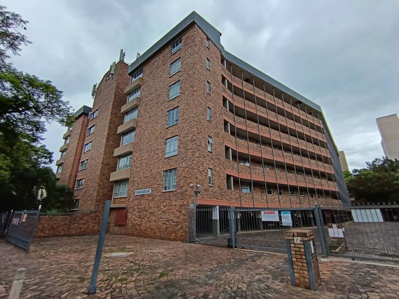 Exterior view of the Makwassie apartment building featuring a face brick facade, secure gated entrance, and multiple levels with balconies.