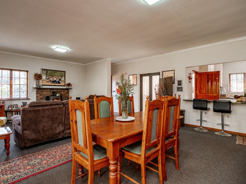 Open plan living and dining area featuring a brick fireplace with wood burning stove and a breakfast bar connecting to the kitchen.