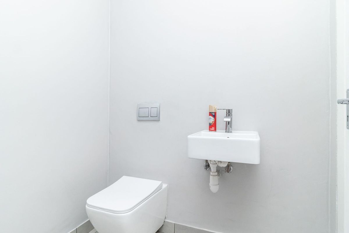 A clean and modern guest bathroom featuring a wall-mounted basin and a concealed cistern toilet.