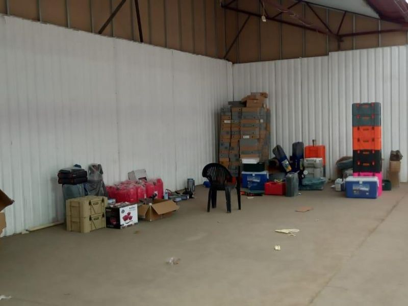 Spacious industrial utility area featuring corrugated metal wall cladding, exposed steel roof trusses, and durable concrete flooring, suitable for storage or workshop use.