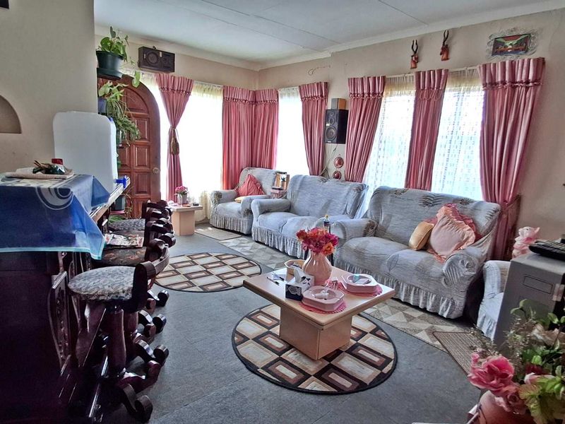 A living room featuring an arched wall niche and timber entrance door, requiring cosmetic updates to modernize the space.