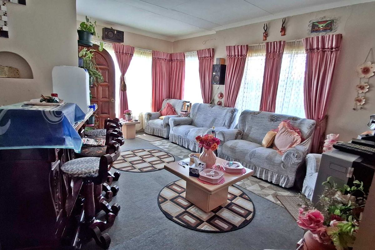 A living room featuring an arched wall niche and timber entrance door, requiring cosmetic updates to modernize the space.