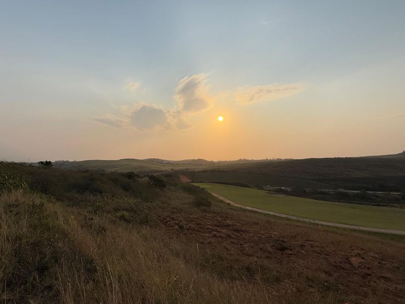 A scenic view of the vacant residential land at sunset, showcasing the natural landscape and rolling hills of the property.