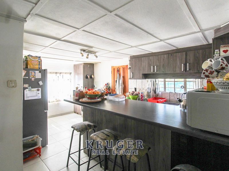 A functional kitchen featuring dark wood-look cabinetry, a breakfast bar, and tiled flooring, offering a practical layout for daily meal preparation.