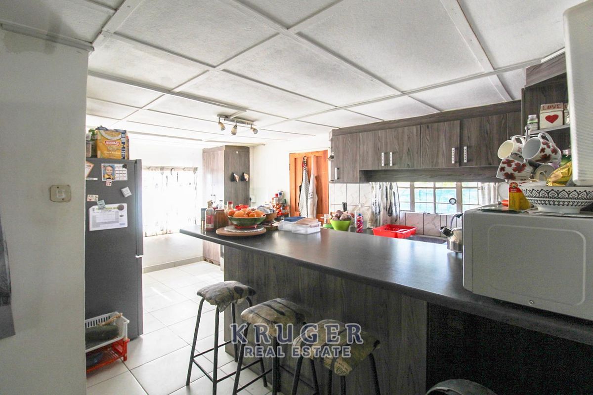 A functional kitchen featuring dark wood-look cabinetry, a breakfast bar, and tiled flooring, offering a practical layout for daily meal preparation.