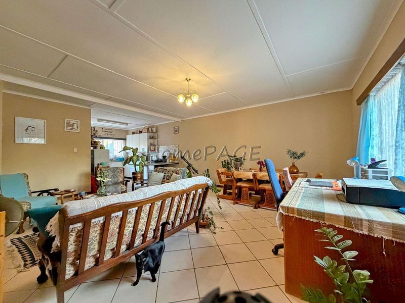 Spacious open-plan living and dining area featuring tiled flooring and a connected kitchen space, offering a functional layout for family living.
