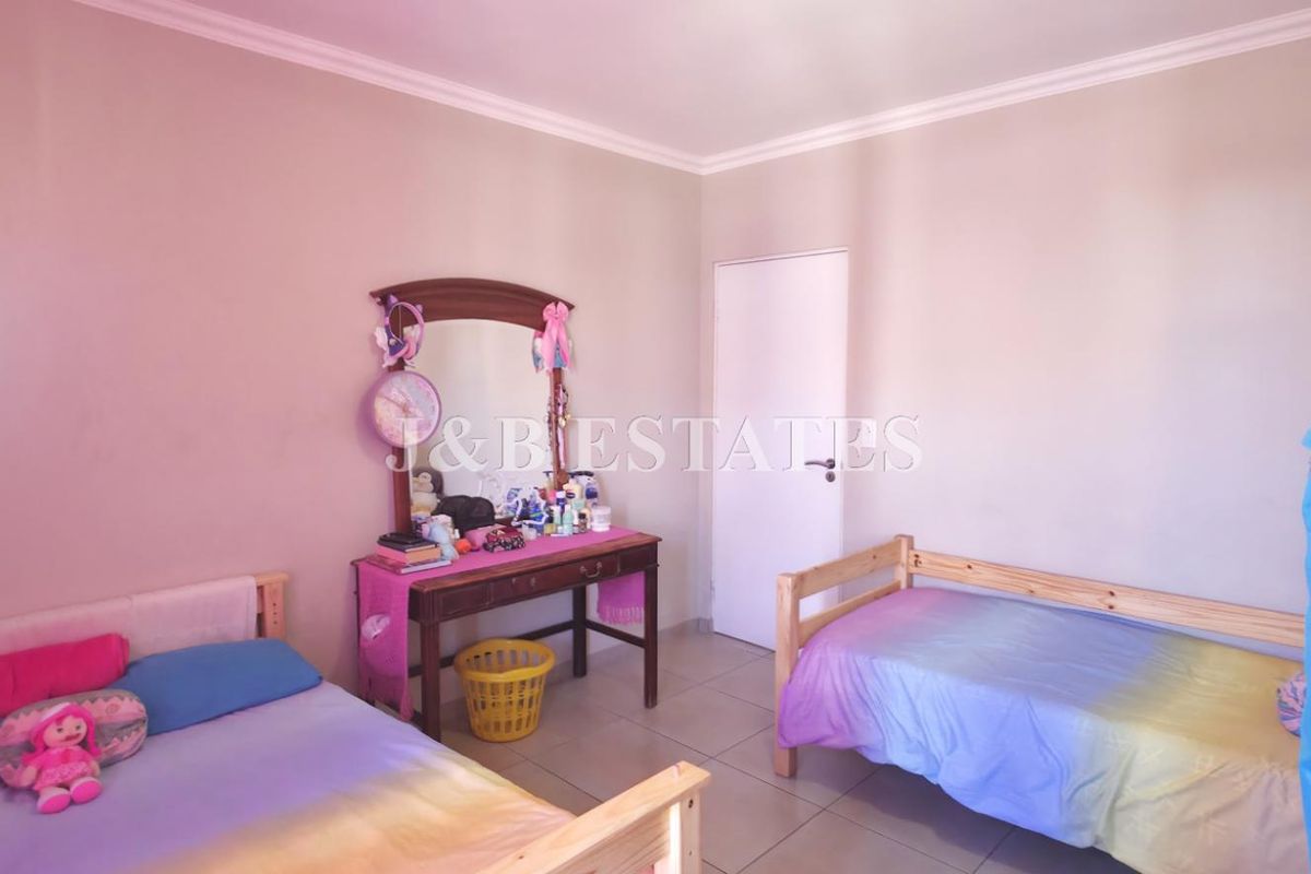 A bedroom featuring tiled flooring and neutral wall finishes, providing a functional space for residents.