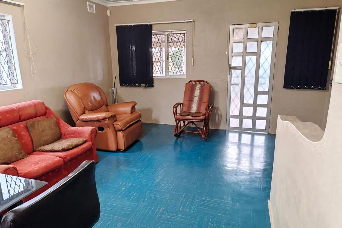 Living room featuring textured ceilings, security bars on windows, a security gate, and blue vinyl flooring.