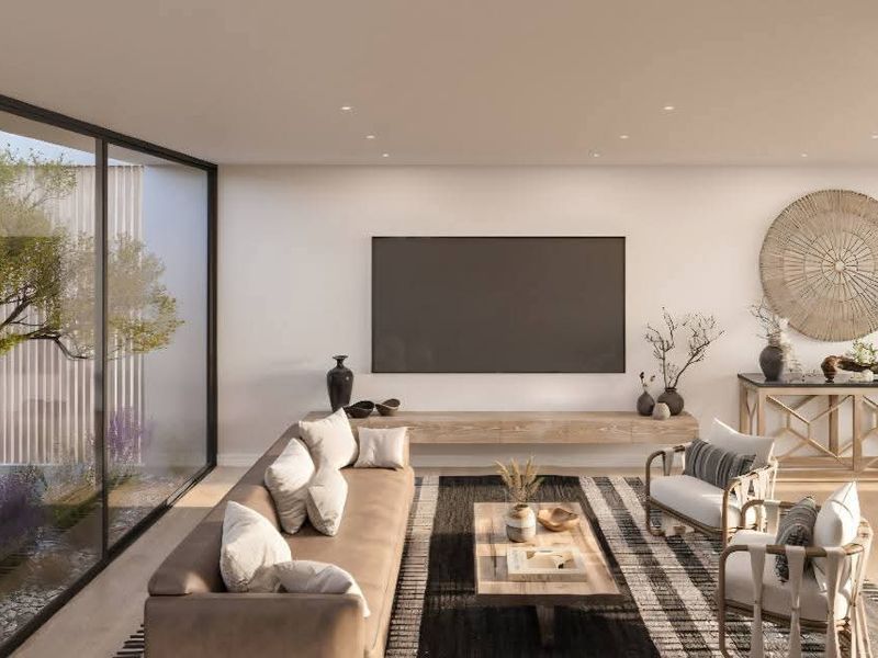 Modern open-plan living area featuring floor-to-ceiling glass doors overlooking a private courtyard, recessed lighting, and a sleek floating media console.