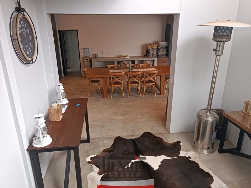 Open plan living and dining area featuring polished concrete flooring and a built-in concrete console unit.
