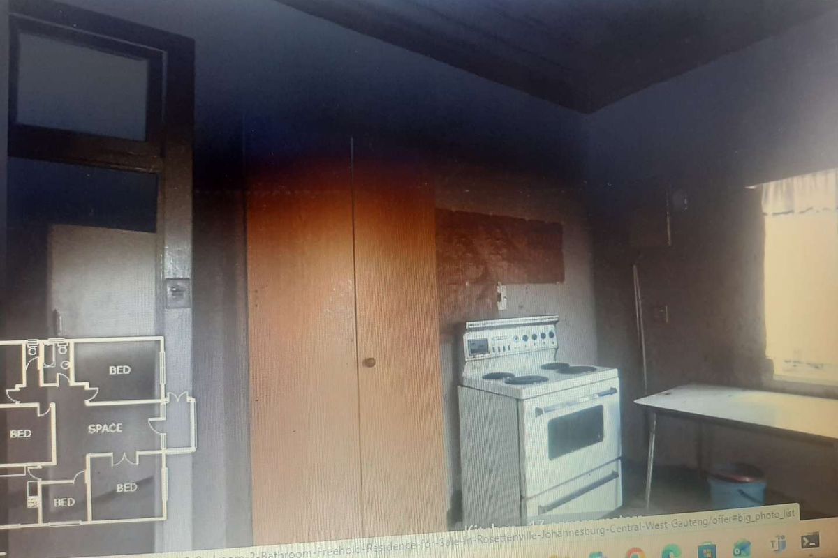 A dated kitchen area featuring a freestanding stove and built-in cupboard, requiring significant renovation and cosmetic updates to modernize the space.