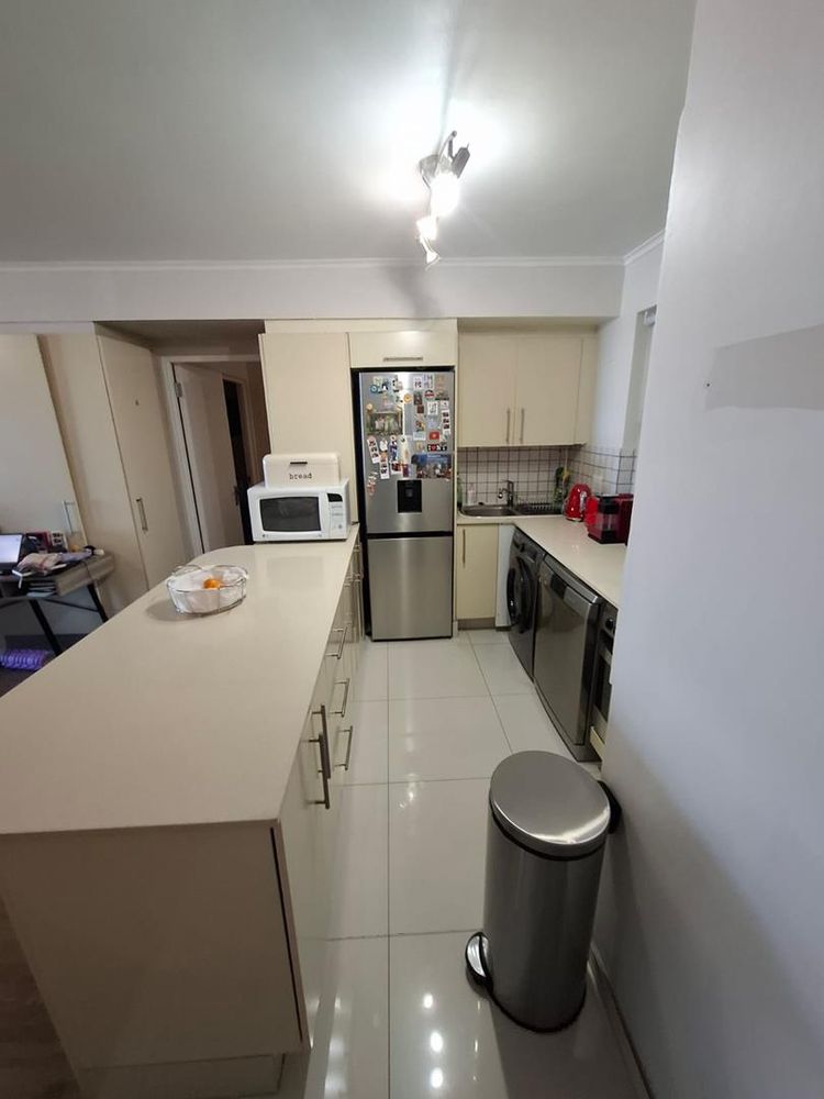 Open kitchen with washing machine, dishwasher and fridge