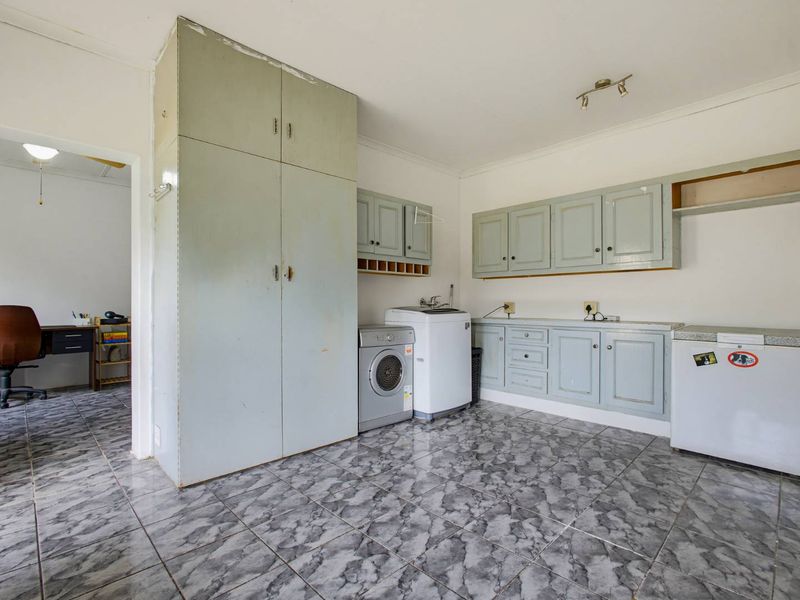Functional laundry room featuring tiled flooring and built-in cabinetry with space for laundry appliances.