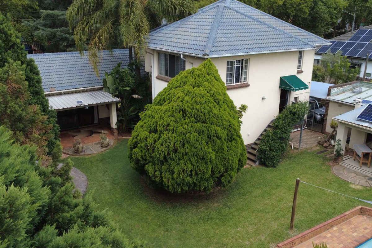 Aerial view of the property showing the rear garden, patio area, and main house structure with tiled roofing.