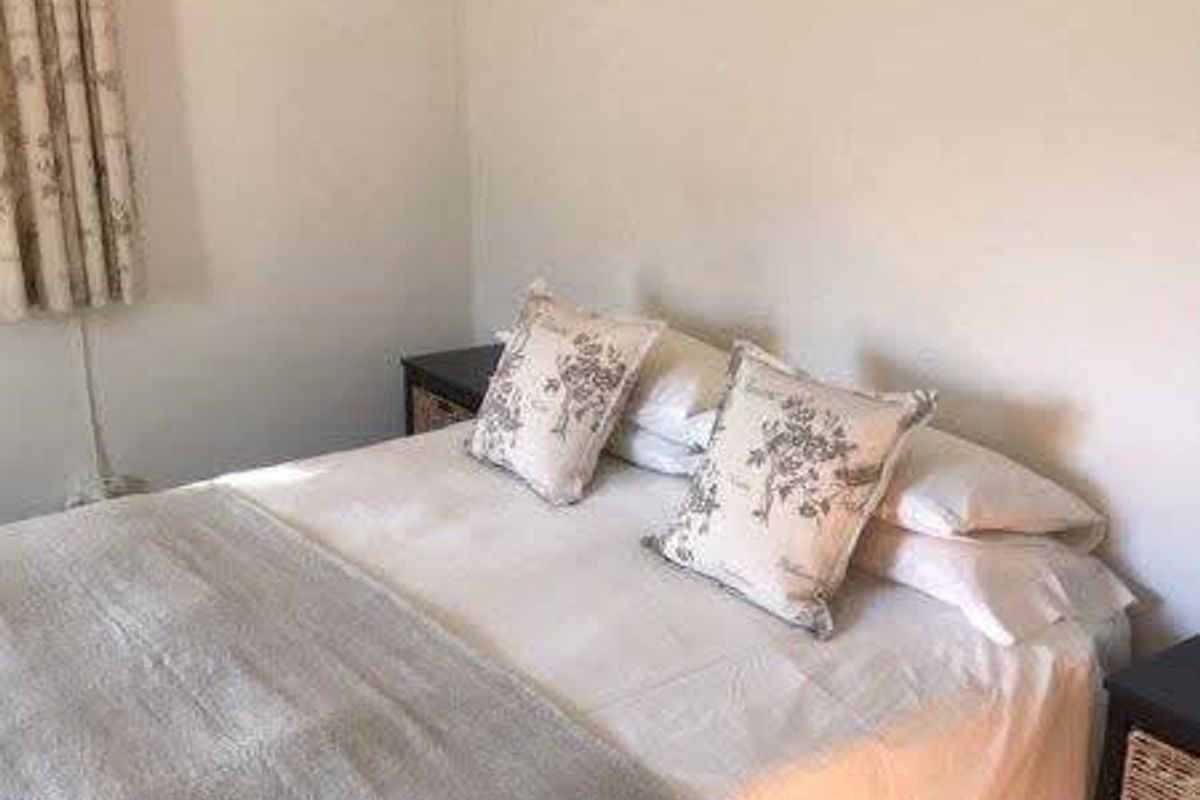 A simple bedroom featuring neutral walls and a functional layout, suitable for comfortable living.