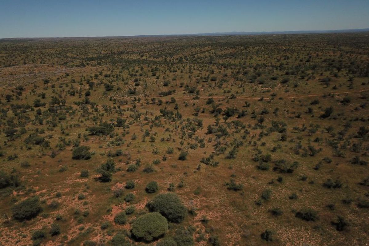 An aerial view of expansive, undeveloped residential land featuring native scrub vegetation and natural terrain.