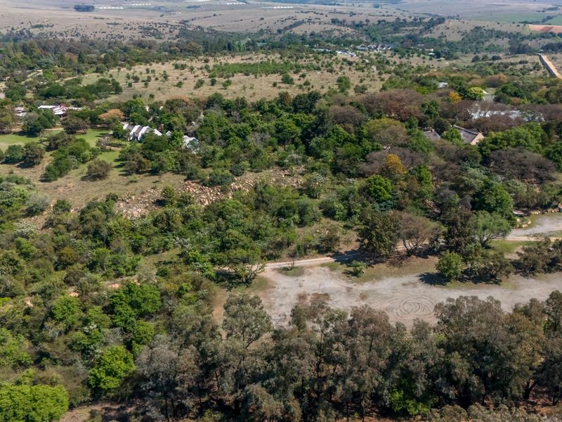 An aerial view of the expansive small holding property, showcasing mature vegetation, natural landscape, and established access paths across the terrain.